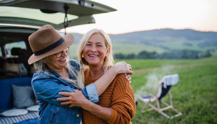 Twee vrouwen houden elkaar lachend vast