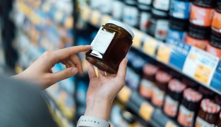 Vrouw checkt etiket in supermarkt