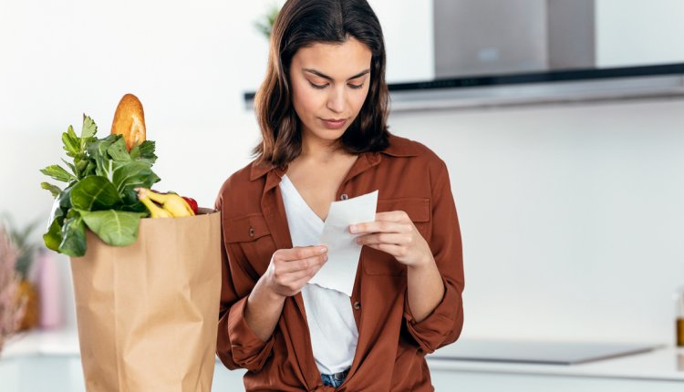 Vrouw kijkt naar kassabon van de boodschappen