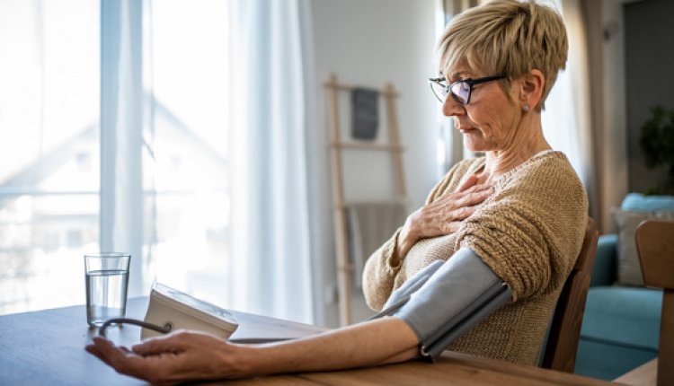 Vrouw meet thuis haar bloeddruk met bloeddrukmeter