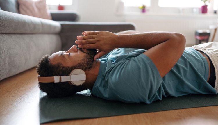 man meditatie net koptelefoon op de vloer