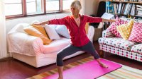 Oudere dame doet aan yoga in kleurrijke yoga kamer